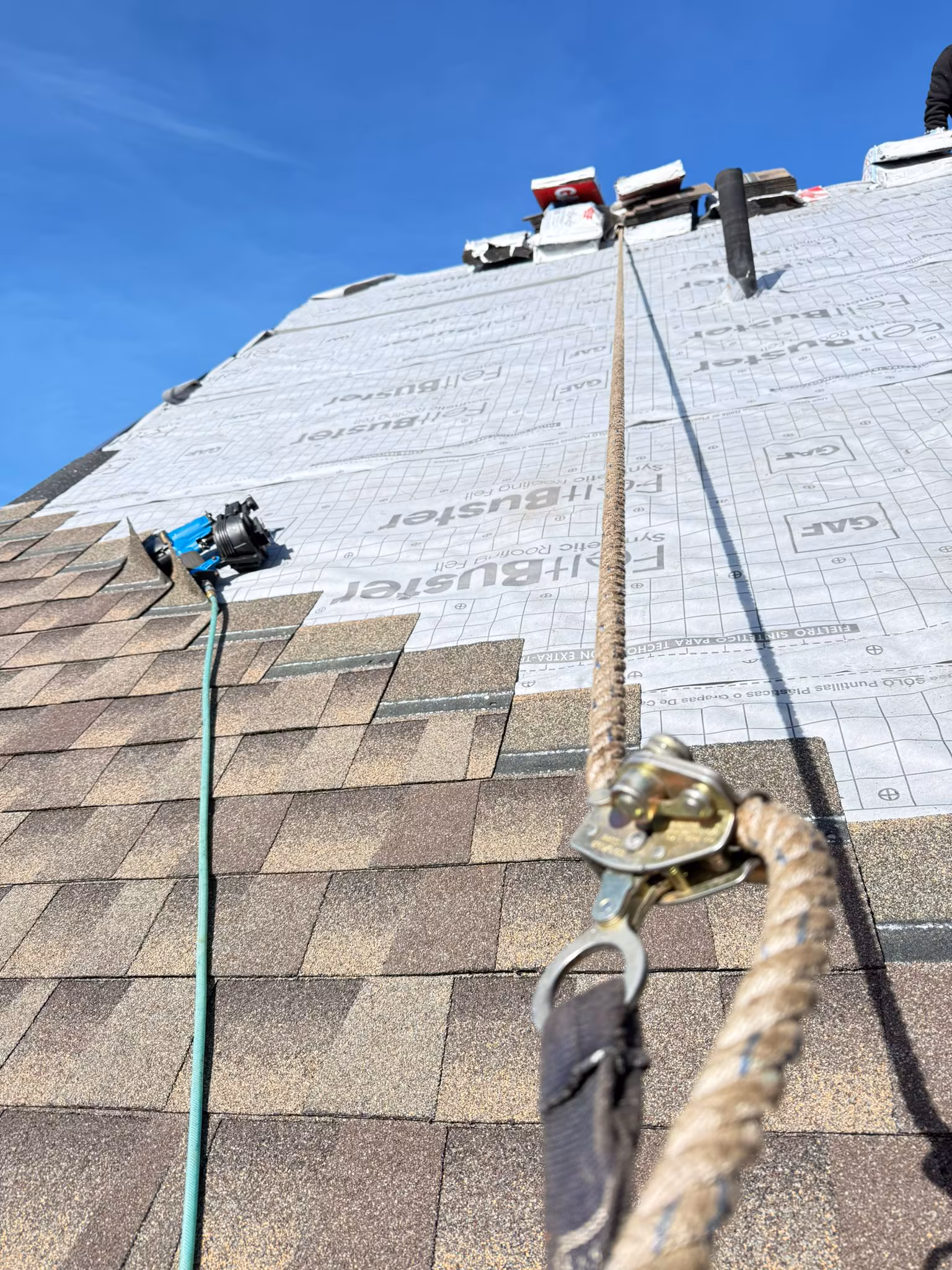 Asphalt shingle roof installation in progress with GAF FeltBuster synthetic underlayment — Kelowna, BC