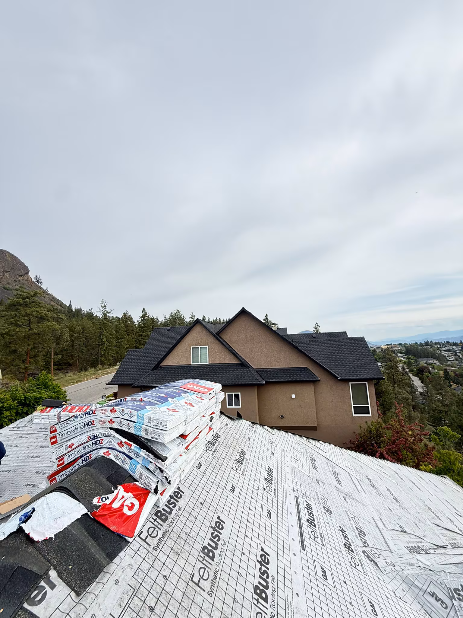Quality roofing workmanship showing clean roof-to-wall transition flashing — West Kelowna