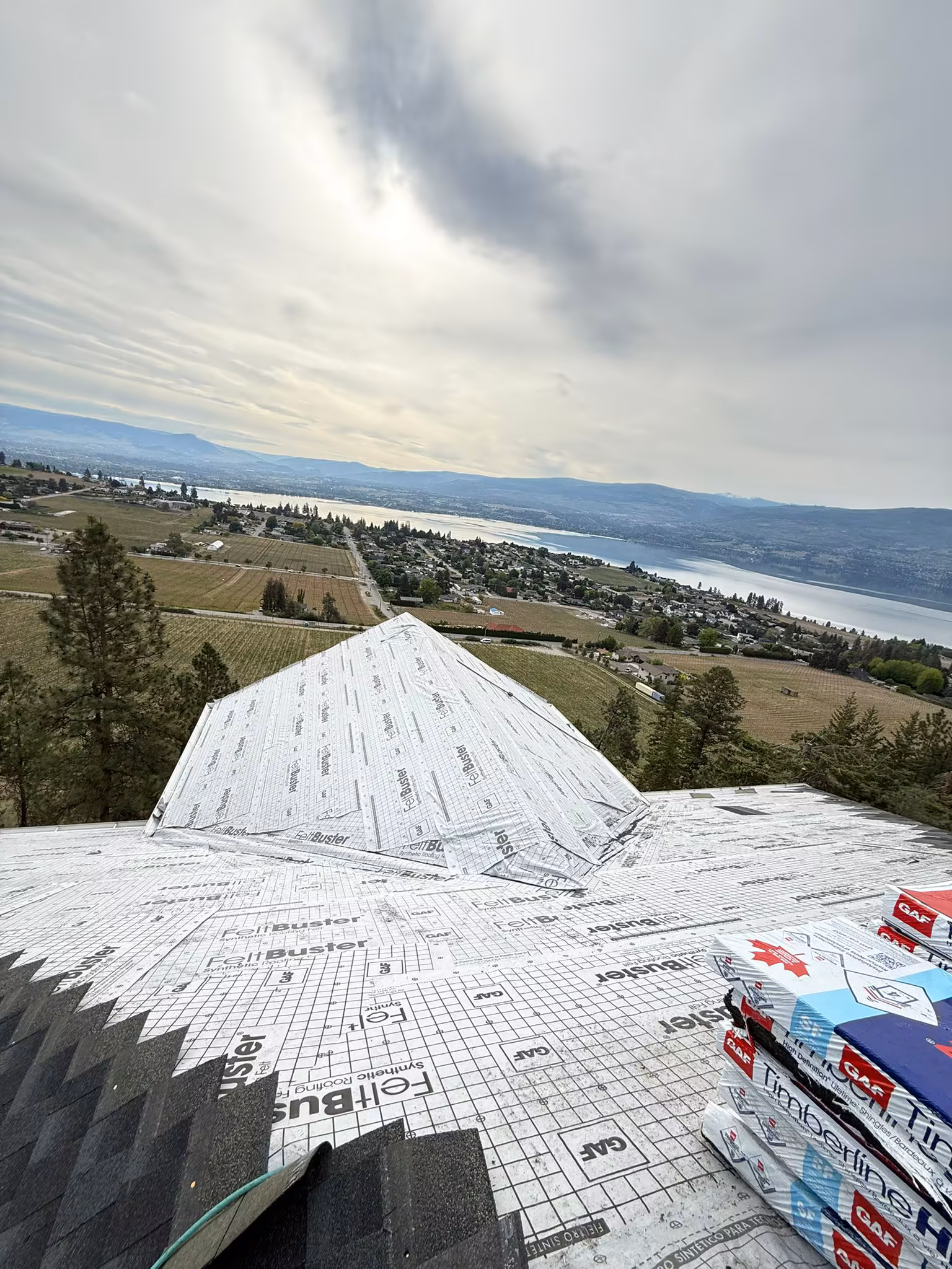 New roof replacement showing ridge cap installation and proper ventilation — West Kelowna