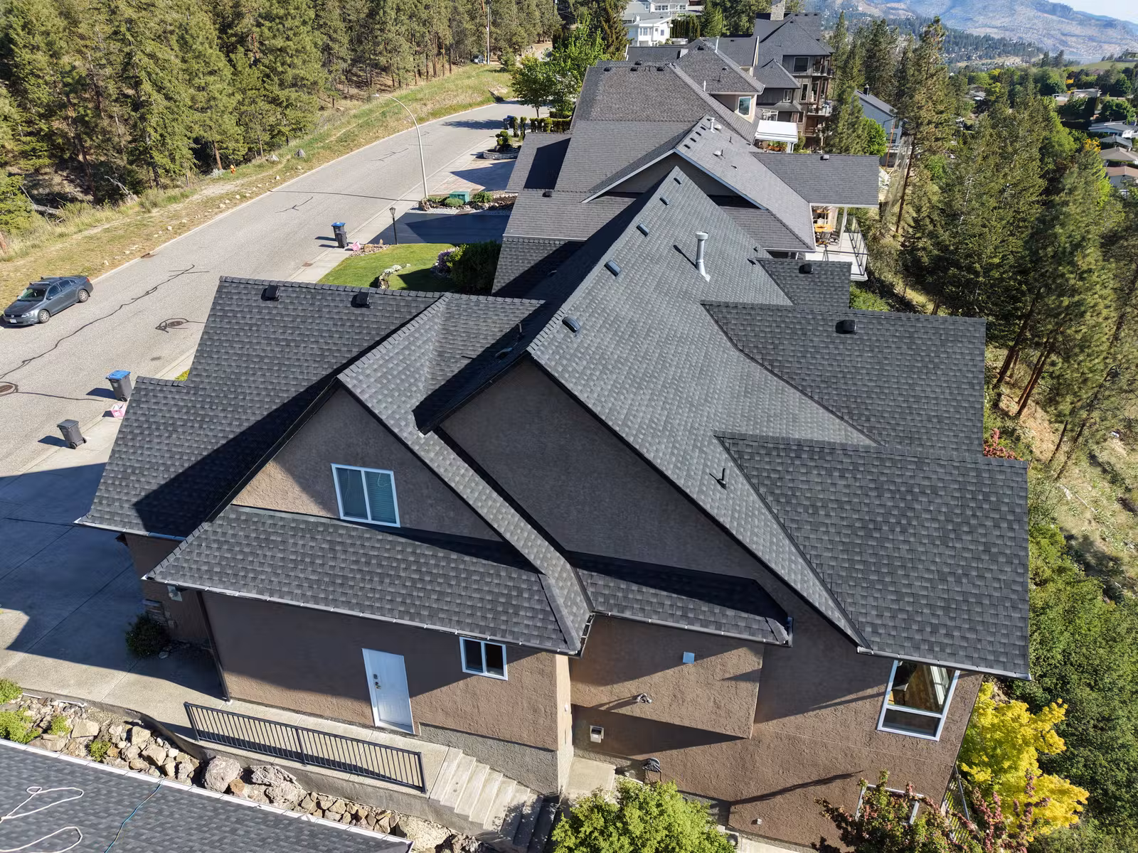 Aerial view of repeated gables and lower porch roofs in West Kelowna