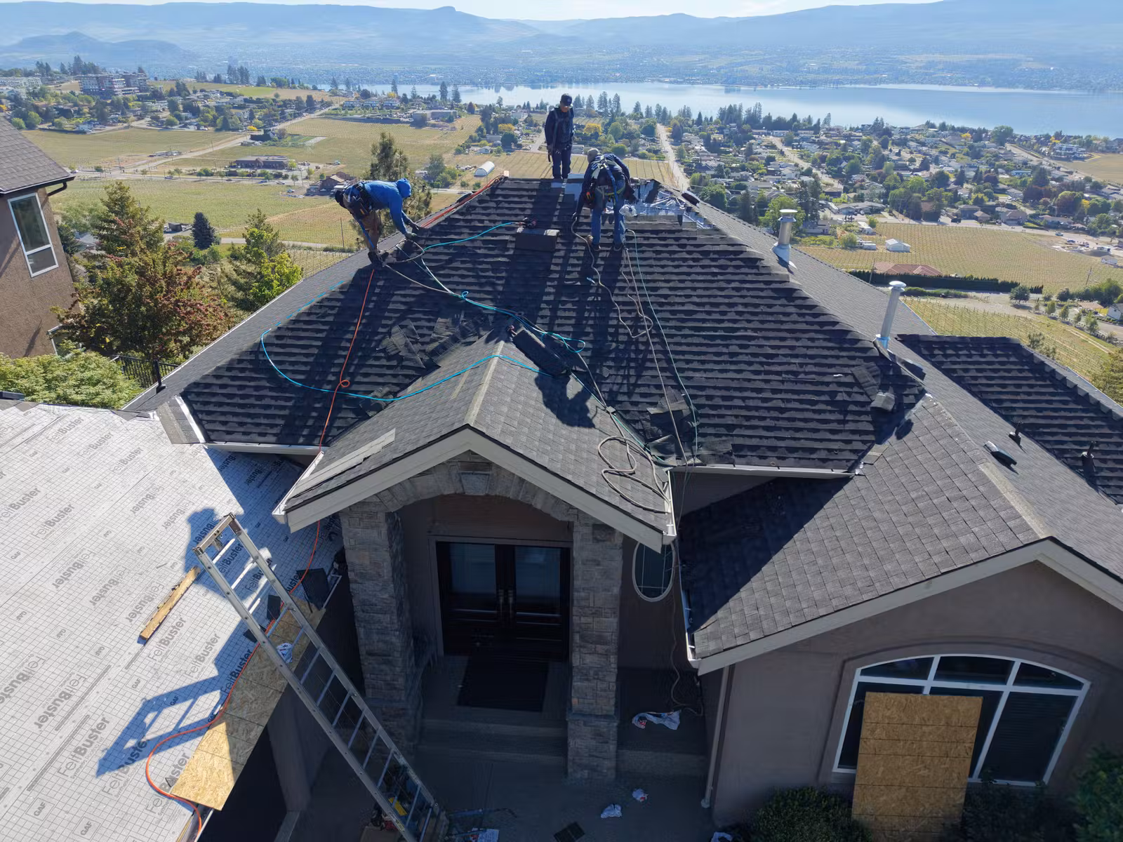 Roof tear-off underway on a lake-facing West Kelowna home