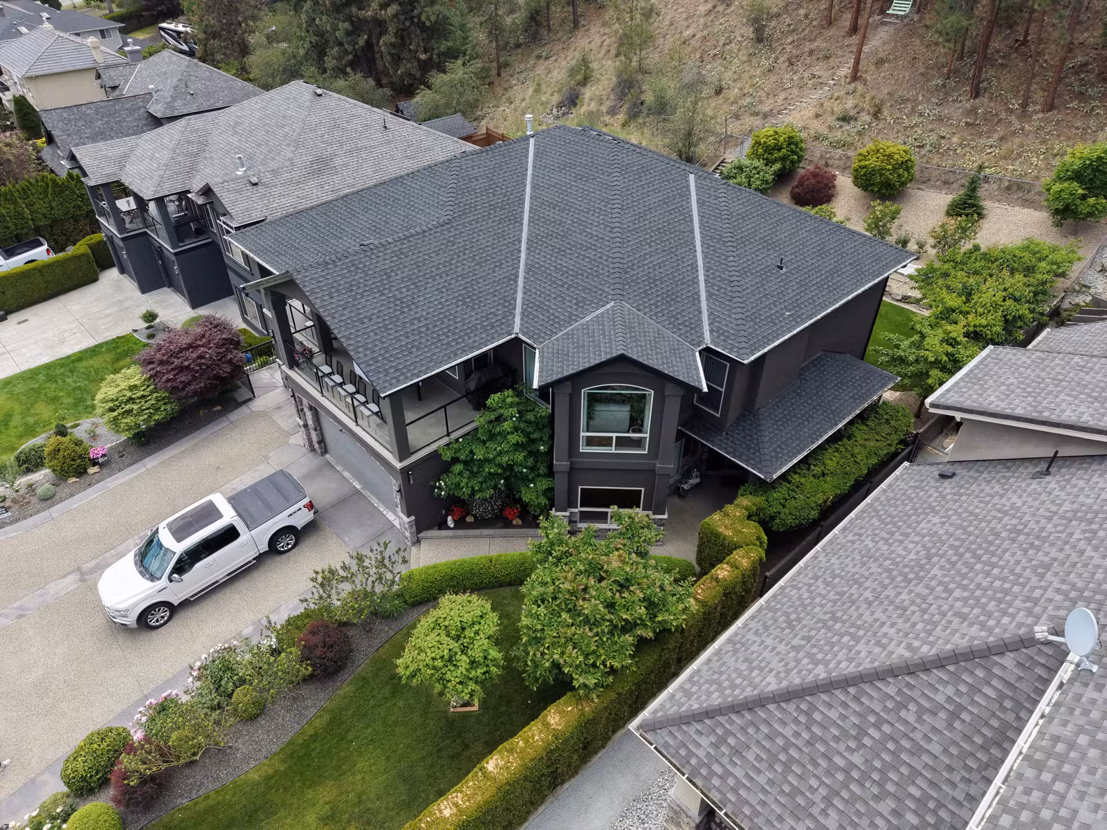 Street-side aerial view of a hillside roof replacement in West Kelowna